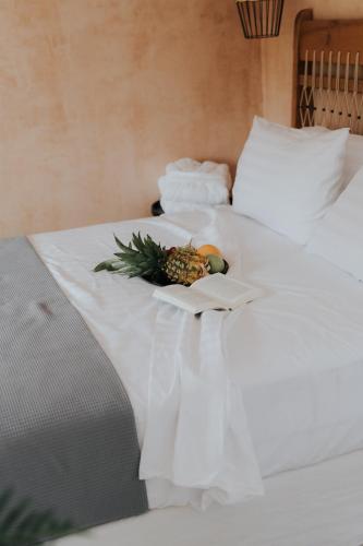 a pineapple on a plate on a bed at elia boutique hotel in Parga