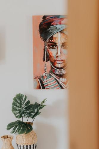 a painting of a woman with a hat on a refrigerator at elia boutique hotel in Parga