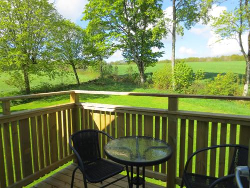 a table and chairs on a deck with a view at Joastorps Bed & Breakfast in Ullared