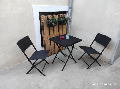 a table and two chairs next to a fence at Room Anthea 2 in Opatija