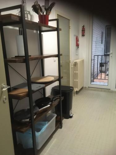 een boekenplank in een kamer met een deur en een deuropening bij Residentie Jan Bart in Oostende