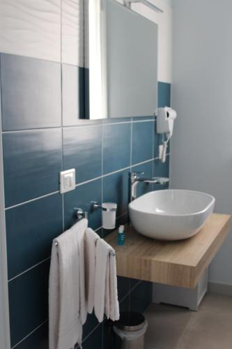 Un baño con un lavabo blanco y un espejo. en B&B L'EDEN DI CAPO BIANCO, en Montallegro