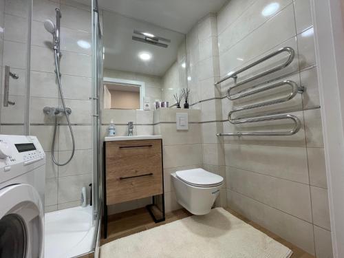 a bathroom with a shower and a toilet and a sink at Apartamentai 128 in Panevėžys