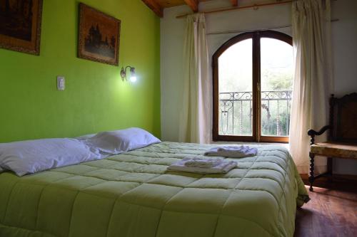 a bedroom with a large bed with a window at Estancia Santa Leocadia in Bialet Massé