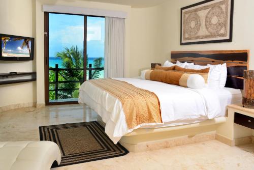 a bedroom with a bed with a view of the ocean at El Taj Oceanfront and Beachside Condo Hotel in Playa del Carmen