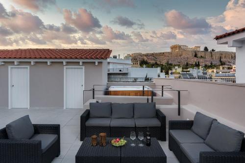 un patio con 2 divani e un tavolo sul tetto di THIRAMENOUS RESIDENCE ad Atene