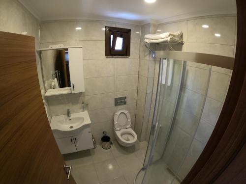 e bagno con servizi igienici, lavandino e doccia. di Şavşat Karagöl Hotel a Savsat
