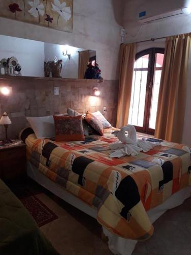 a bedroom with a large bed with a stuffed animal on it at Estancia Santa Leocadia in Bialet Massé