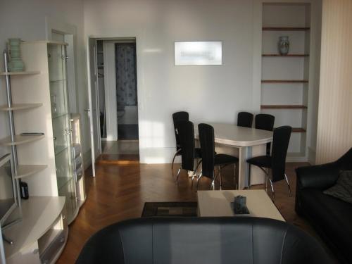 a living room with a table and black chairs at Appartements Vacances Saars 33 in Neuchâtel