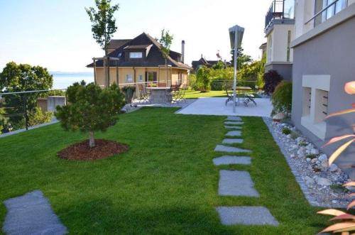 a backyard with a lawn with a tree and a house at Appartements Vacances Saars 33 in Neuchâtel