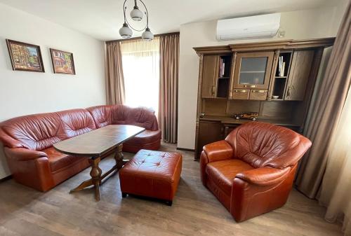 a living room with leather furniture and a table and chairs at RELAX Apartments in HASKOVO, Apt1 in Haskovo