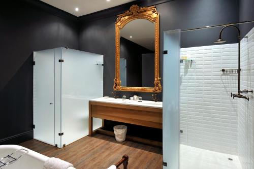 a bathroom with a mirror and a sink at La Clé Village in Franschhoek
