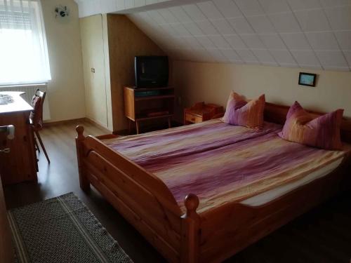 a bedroom with a large bed and a television at Apartment Keszthely 4 in Keszthely