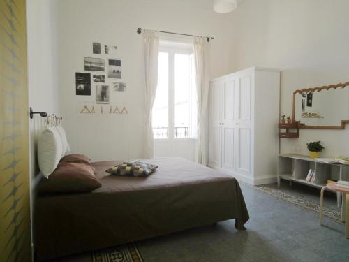 a bedroom with a bed in a room with a window at Serafino B&B in Palermo