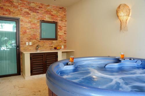 a large blue tub in a bathroom with a sink at El Taj Oceanfront and Beachside Condo Hotel in Playa del Carmen