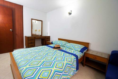 a bedroom with a bed and a dresser and a mirror at Apartamento - 3 Dormitorios en el Rodadero ツ in Puerto de Gaira