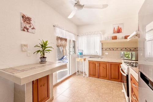 a kitchen with wooden cabinets and a ceiling fan at Casa Nona Rosa in Cancún