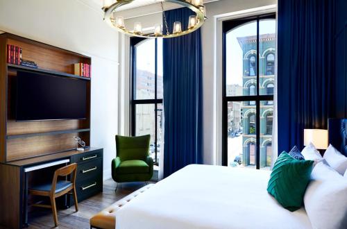 路易斯威尔The Grady Hotel的一间带床和电视的酒店房间