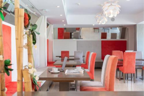 a dining room with a table and orange chairs at Playas del Rey in Santa Ponsa