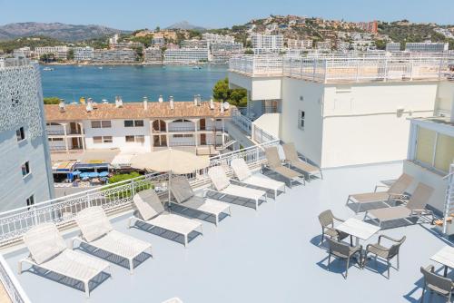 a rooftop deck with lounge chairs and a view of the city at Playas del Rey in Santa Ponsa