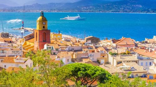 a view of a town with a boat in the water at Les Restanques 2149 vue mer in Grimaud