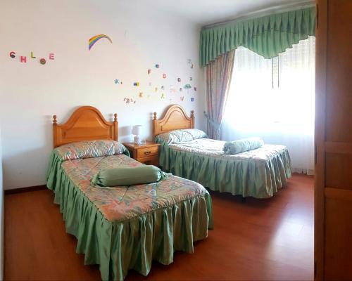a bedroom with two beds and a window at Piso in Cedeira