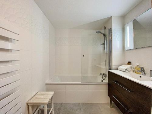 La salle de bains blanche est pourvue d'une baignoire et d'un lavabo. dans l'établissement L'ancre Marine YourHostHelper, à Deauville