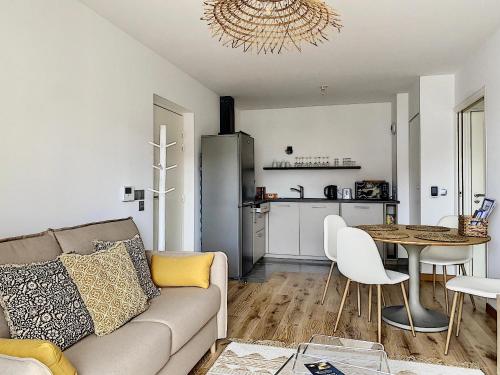 un salon avec un canapé et une table dans l'établissement L'ancre Marine YourHostHelper, à Deauville