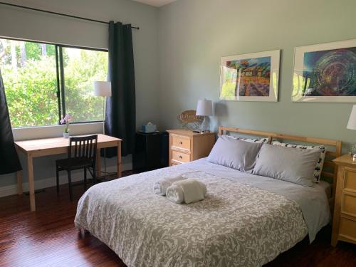 a bedroom with a bed and a desk and a window at Rancho Garden Home in Rancho Santa Fe