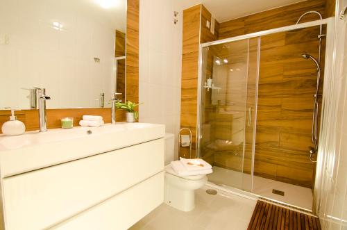 uma casa de banho com um WC e uma cabina de duche em vidro. em Valente Flat by Serendipia Turismo em Santiago de Compostela