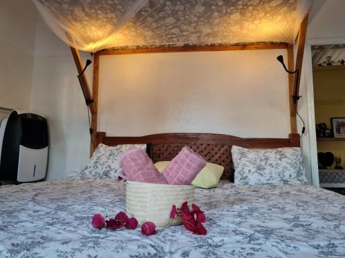 a bed with pink flowers and a basket on it at Casa Brisa in Inhambane