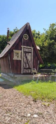 een klein houten huis met een deur in een tuin bij Casa mirabilia in Pléneuf-Val-André