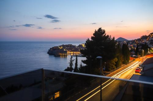a view of the ocean and a city at sunset at New&Luxury Apartment with an Outstanding View - Bombii Blue in Dubrovnik