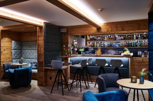 a bar in a restaurant with blue chairs and tables at Matthiol Boutique Hotel in Zermatt