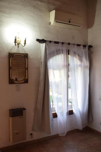 a window with white curtains in a room at Estancia Santa Leocadia in Bialet Massé