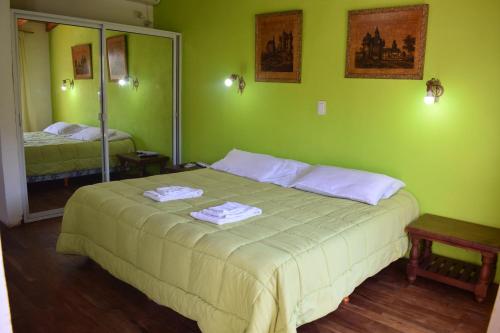 a green bedroom with a bed with towels on it at Estancia Santa Leocadia in Bialet Massé