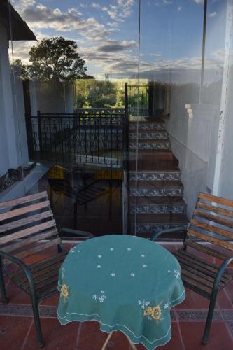 a patio with a table and chairs on a balcony at Estancia Santa Leocadia in Bialet Massé