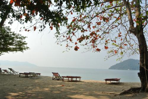 a group of benches on a beach near the water at Bangbaobeach Resort in Ko Chang