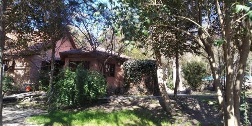 a brick house with trees in front of it at Complejo de Cabañas Estancia Del Águila in Mina Clavero