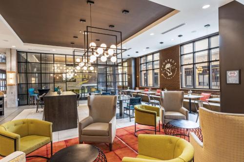 a restaurant with chairs and tables and windows at Hotel Indigo Tulsa DWTN/Entertainment Area in Tulsa