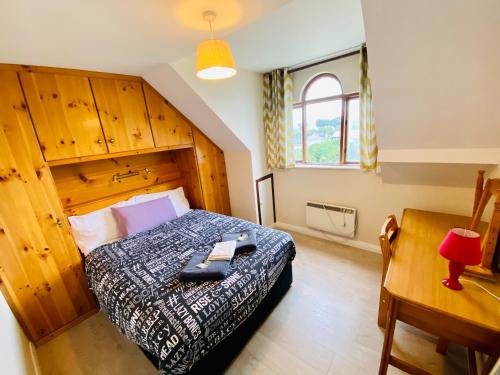 1 dormitorio con cama con cabecero de madera y escritorio en Crescent Close, en Galway