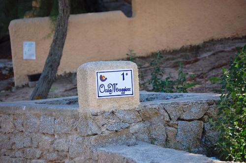 a sign on the side of a stone wall at La Casetta Nella Baia in Santa Teresa Gallura