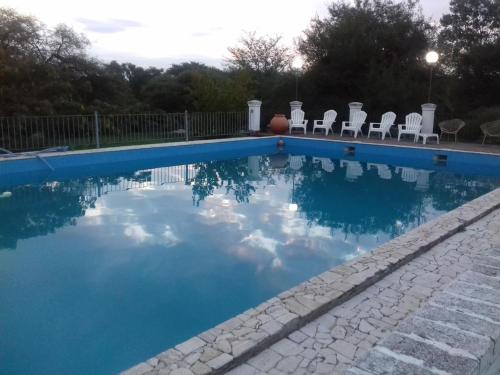 a swimming pool with chairs and a ball in the water at Estancia Santa Leocadia in Bialet Massé