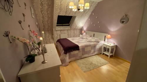 um pequeno quarto com uma cama e uma televisão em Petit coin de Paradis em Cancale