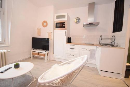 cocina blanca con mesa y fregadero en APPART COCON - HYPER CENTRE - TRAM - FREE WIFI - leRelaisdOdile24, en Valenciennes