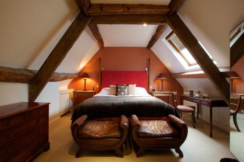 a bedroom with a large bed and two chairs at Cotswold House Hotel and Spa - "A Bespoke Hotel" in Chipping Campden