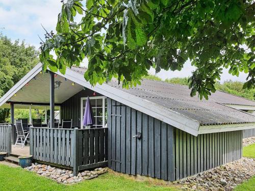 a green building with a porch and a patio at 6 person holiday home in Sydals-By Traum in Neder Lysabild
