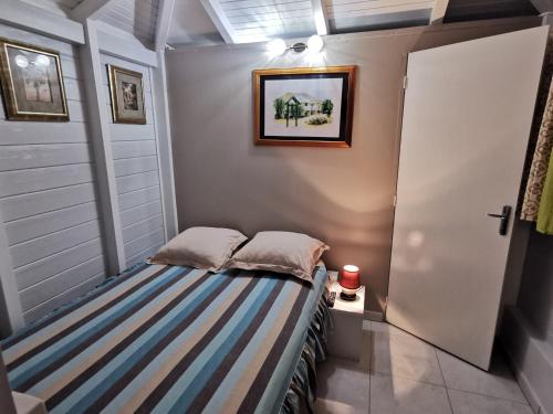 La Suite Odile Piscine في لو لامينتين: سرير صغير في غرفة مع باب
