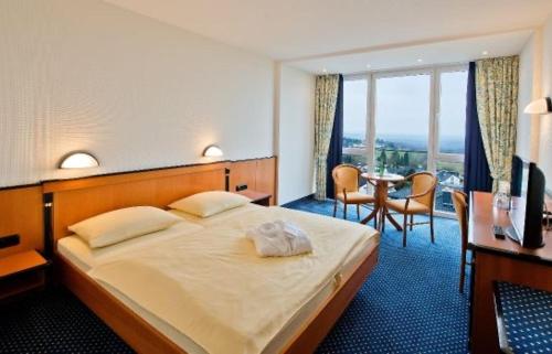 um quarto de hotel com uma cama, uma mesa e cadeiras em Panorama Hotel em Glashütten