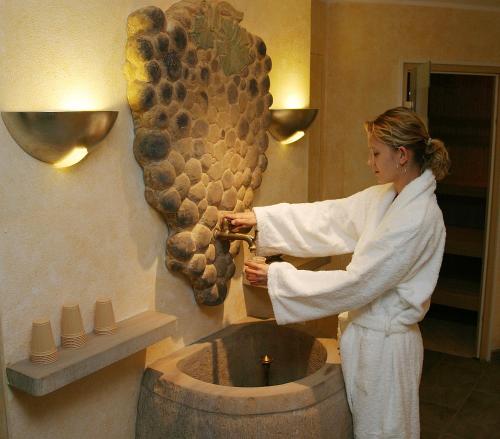a woman standing in a bathroom with a sink at Hotel Weinbauer in Schwangau